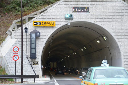 対面通行2車線のトンネル内を自動車が走行しています。