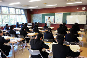 中学生を前に下水道の説明をしています。